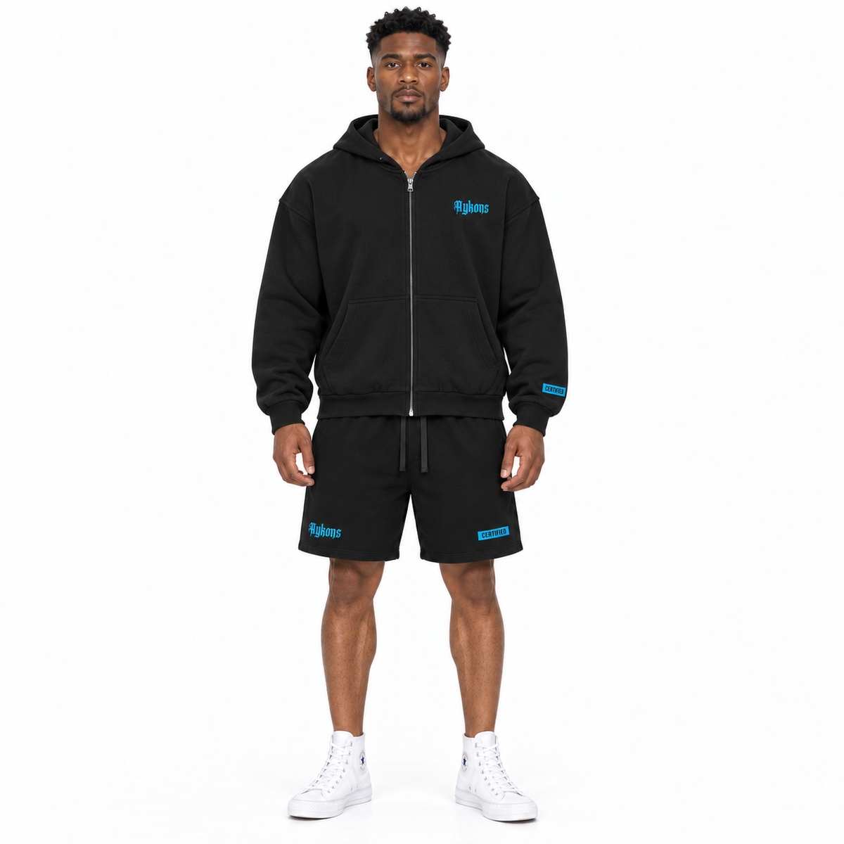 AYKONS [400] Solomon's Secrets Zip hoodie in black and blue - Model 2 straight front full-body shot with matching blue embroidered CERTIFIED shorts and all-white high-top Converse.