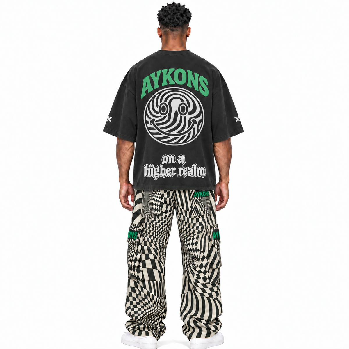 AYKONS Distorted Reality V2 cargo pants and PsySmile tee — model straight back, white Air Force 1 shoes.