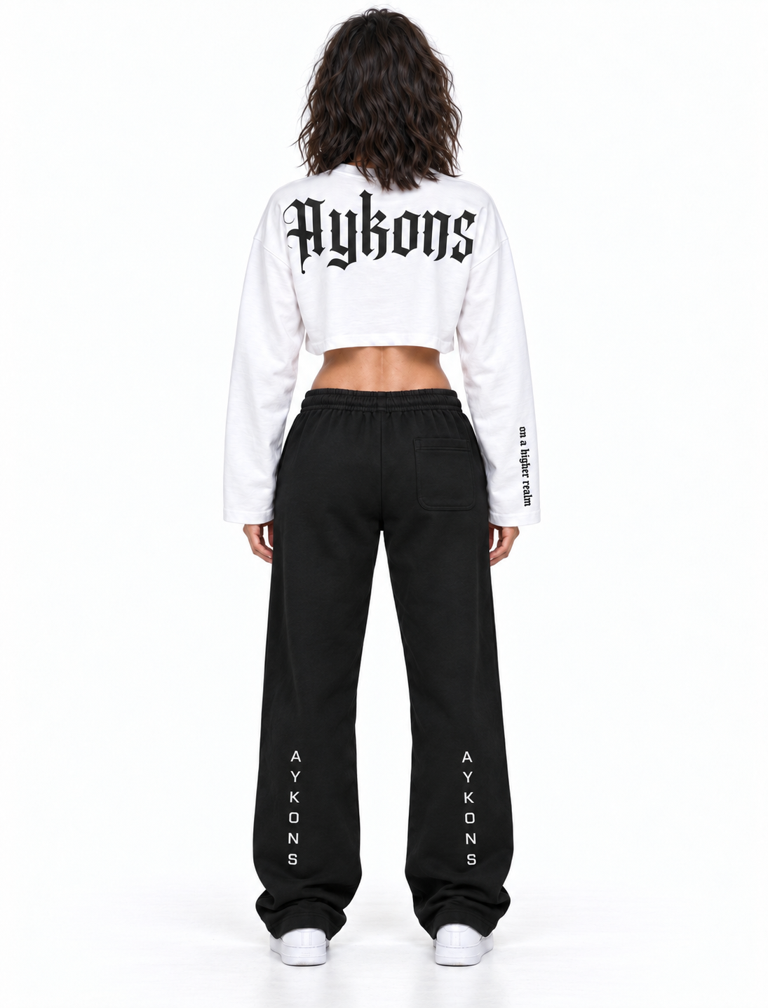 White and black AYKONS Racer Crop — Women Model 1 back view with black AYKONS sweatpants